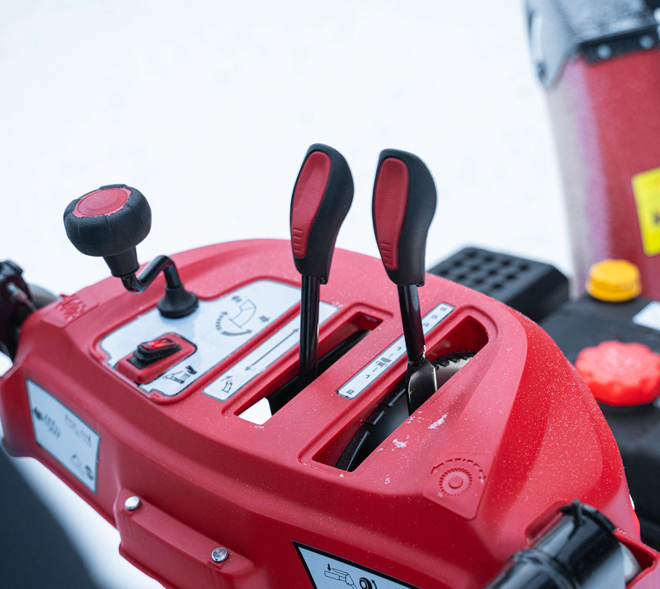 <b>Многофункциональная панель оператора</b>.
Snow Line 560 - переключение скоростей. Направление выбросом осуществляется рукояткой под панелью.
На моделях Arctic Line на панель оператора, помимо управлением КПП, выведены управление выбросом, кнопки включения подогрева рукояток и освещением.